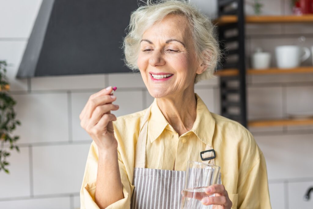 femme senior qui prend des compléments alimentaires