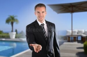 agent immobilier en costume devant villa luxueuse