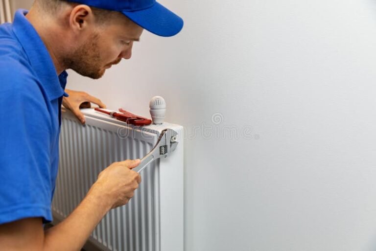 apprenti plombier travaillant sur radiateur moderne