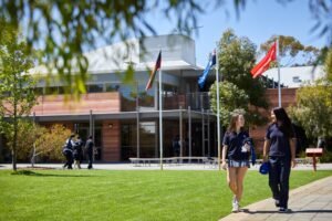 etudiant reflechissant devant un batiment scolaire moderne