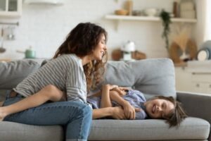 nounou souriante jouant avec enfant a domicile 1