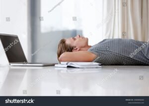 personne reflechissant devant un ordinateur avec livres