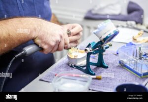prothesiste dentaire travaillant sur prothese detaillee
